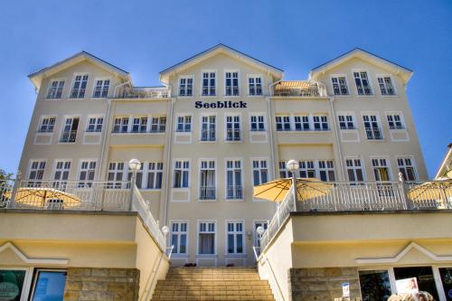 een groot wit gebouw met een trap ervoor bij Haus Seeblick Hotel Garni & Ferienwohnungen in Zinnowitz