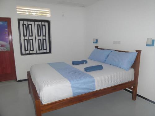 米瑞莎Coralworld Hotel的卧室里有一张床，上面放着蓝色的枕头