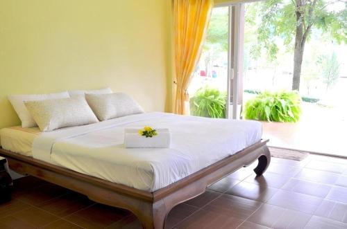 a bedroom with a bed with a flower box on it at At Home Suanphung in Ratchaburi