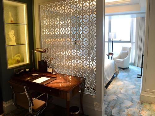 a room with a desk and a bedroom with a bed at Xian Jue Vu Hotel in Xi'an