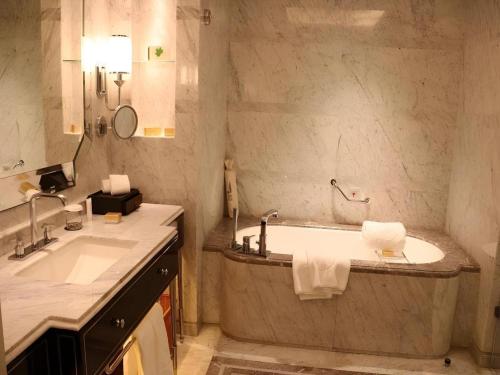 a bathroom with a large tub and a sink at Xian Jue Vu Hotel in Xi'an
