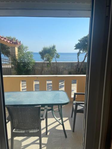 a table and chairs on a balcony with a view of the ocean at evia mourteri Apartment in Mourteri