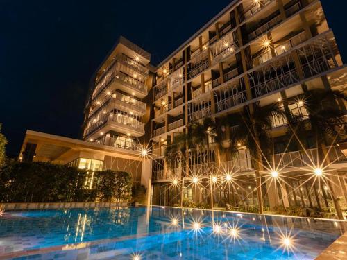 a large building with a swimming pool at night at B2 Krabi Premier Hotel in Ao Nang Beach