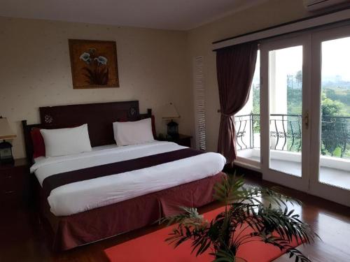 une chambre avec un grand lit et une grande fenêtre dans l'établissement Hotel Scarlet Bukit Pakar, à Bandung