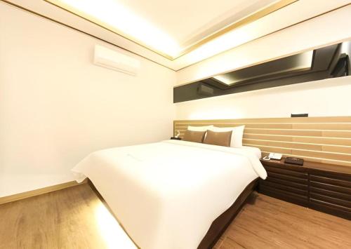 a bedroom with a large white bed in a room at H Hotel in Ulsan