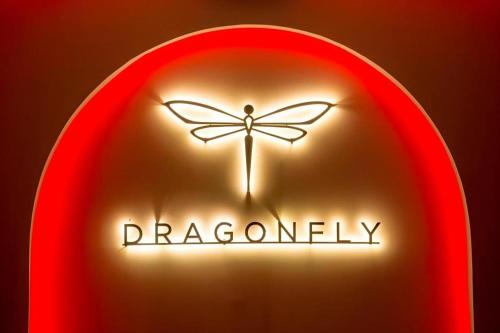 a red neon sign with a dragonfly on it at Sea Suite Villa in Chaweng