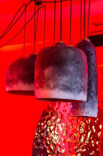 a group of pots hanging from a red wall at Sea Suite Villa in Chaweng