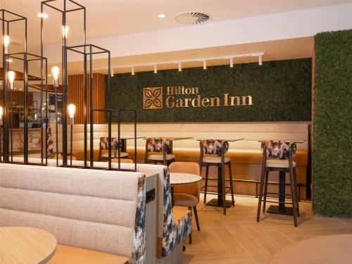 a restaurant with stools and a sign that reads infusion garden inn at Hilton Garden Inn Brussels Airport in Diegem