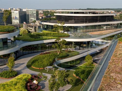 an external view of a building with a garden at Hilton Garden Inn Brussels Airport in Diegem
