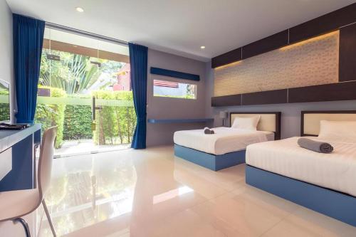 a bedroom with two beds and a large window at Sea Suite Villa in Chaweng