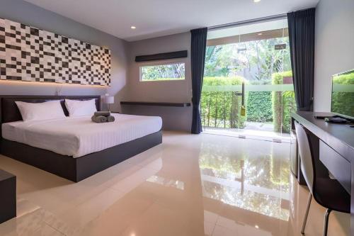 a bedroom with a bed and a television and a window at Sea Suite Villa in Chaweng