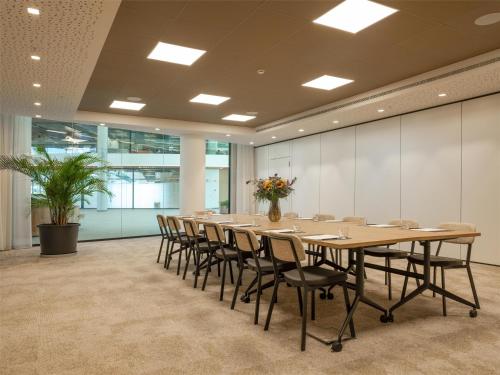 a large conference room with a long table and chairs at Hilton Garden Inn Brussels Airport in Diegem