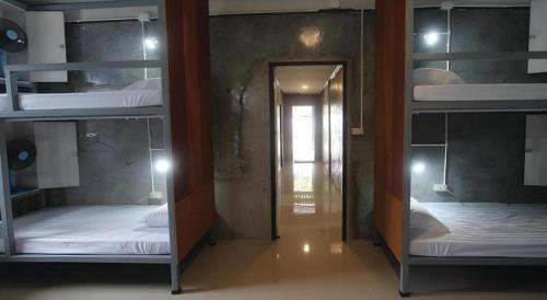 two bunk beds in a room with a mirror at Chomjan Hostel in Ko Phayam