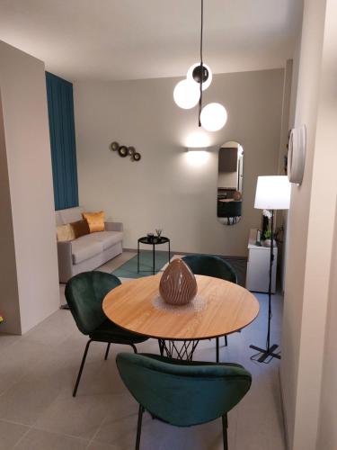 a living room with a table and green chairs at The 6 apartments S in Rimini