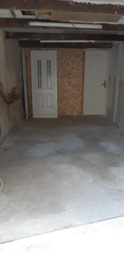 un garage vide avec une porte blanche et une porte d'entrée dans l'établissement Chez Timmy, à Oupia