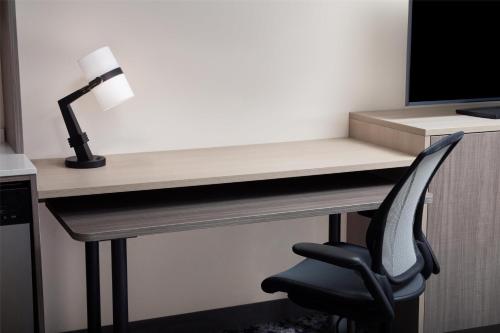 a desk with a chair and a computer monitor at Home2 Suites By Hilton Clearwater St. Petersburg Ulmerton Rd in Clearwater