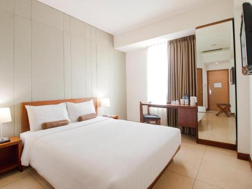 a large white bed in a hotel room at PARK HOTEL Cawang Jakarta in Jakarta