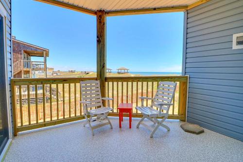 two chairs and a red table on a balcony at SO1A - Shangri-La in Kill Devil Hills