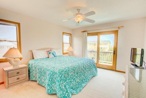 a bedroom with a bed and a tv and a window at 3035 - Morning View in Southern Shores