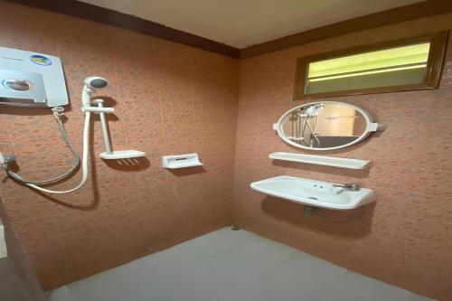 une salle de bain avec un lavabo et un miroir dans l'établissement OYO 75380 Bannoichynum Resort Kanchanaburi, à Ban Tha Kilen (1)