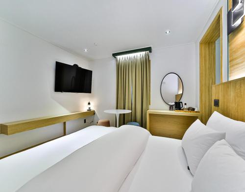 a hotel room with a bed and a television at No 25 Hotel Gumi Wonpyeongdong in Gumi