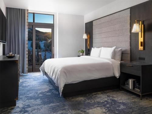 a hotel room with a large bed and a balcony at Grand Hyatt Deer Valley in Park City