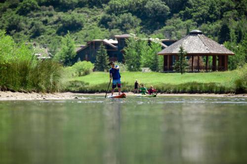 a man is standing on a paddle board in the water at Grand Hyatt Deer Valley in Park City
