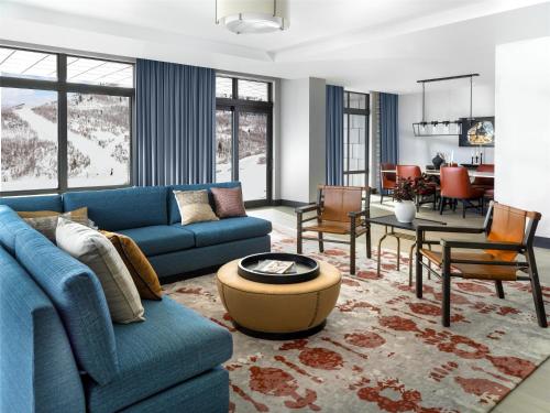 a living room with blue couches and a dining room at Grand Hyatt Deer Valley in Park City