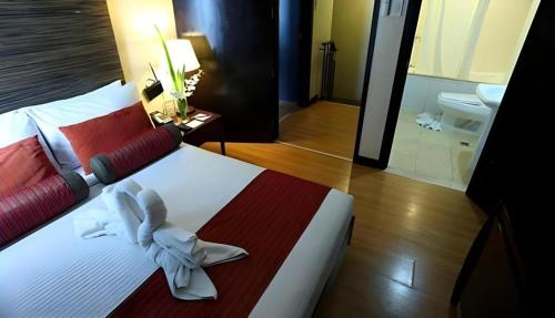 a bedroom with a large bed with a flower on it at Lancaster Hotel Manila in Manila