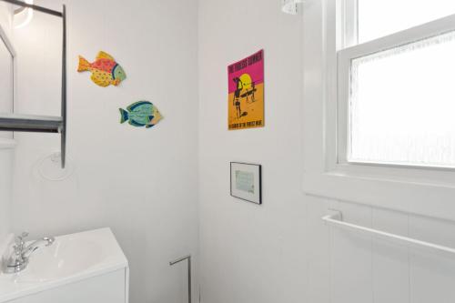 a bathroom with a sink and two signs on the wall at 4119 - The Dolphin Boat in Kitty Hawk
