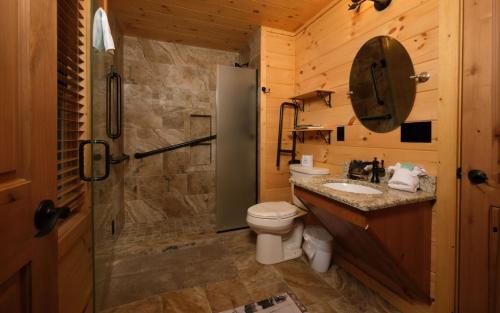 a bathroom with a toilet and a sink and a shower at Hot tub and game room! - Black Bear Crossing in Gatlinburg