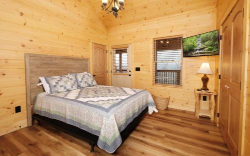 a bedroom with a bed in a log cabin at Hot tub and game room! - Black Bear Crossing in Gatlinburg