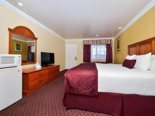 a bedroom with a large bed and a television at Best Western Hanford Inn in Hanford