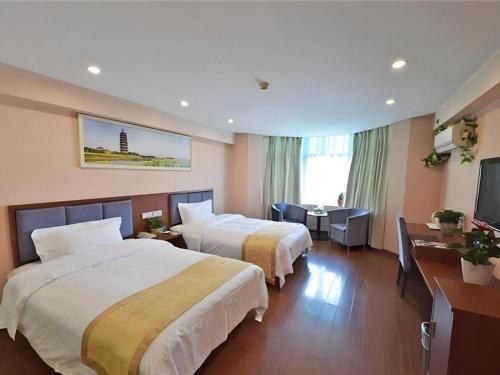 a hotel room with two beds and a flat screen tv at GreenTree Alliance Jiangsu Yangzhou Hanjiang Middle Road Libao Square Hotel in Yangzhou