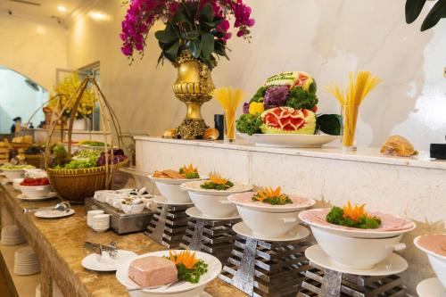 ein Buffet mit Schüsseln voller Essen auf einem Tisch in der Unterkunft Thien Thanh Resort in Phu Quoc