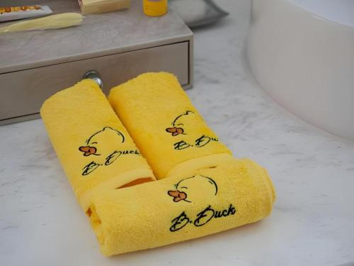 two yellow towels with chickens on them on a counter at Beijing Liaoning Hotel in Beijing