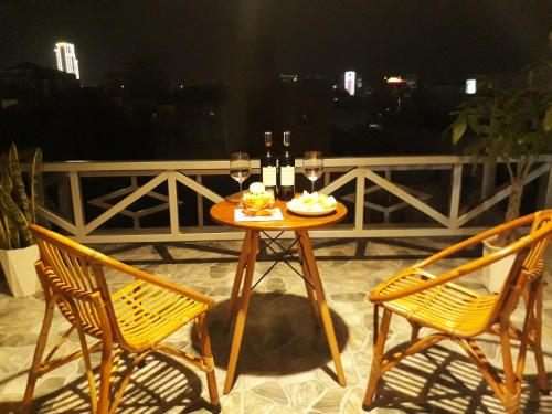 a table with two chairs and glasses of wine at Deluxe Private Room by Adora in Can Tho