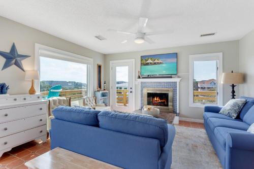 a living room with blue couches and a fireplace at 3043 - Sandy Shores in Southern Shores