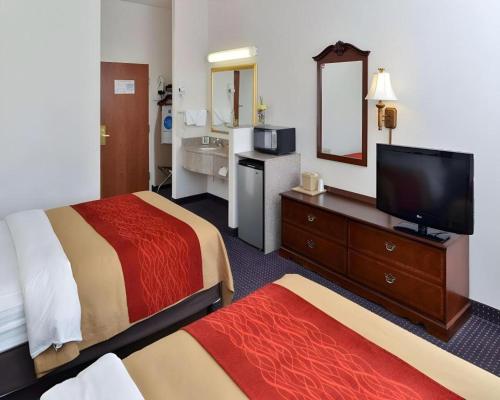 a hotel room with two beds and a flat screen tv at Comfort Inn & Suites in Riverton
