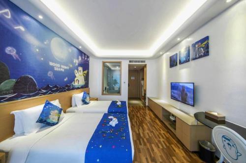 a hotel room with two beds and a tv at Beluga Sanya Discovery Ocean World in Shangsimacun