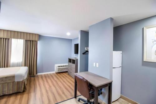 a hotel room with a bed and a desk at Rodeway Inn & Suites Port Arthur - Groves in Port Arthur