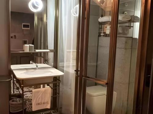 a bathroom with a shower and a sink and a toilet at King's Hotel in Hong Kong