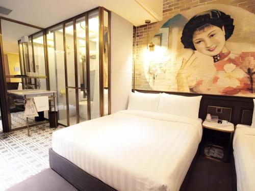 a bedroom with a bed with a painting on the wall at King's Hotel in Hong Kong