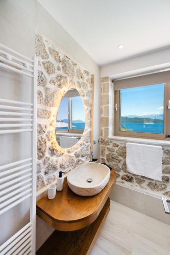 a bathroom with a round sink and a window at Diamanti Villas in Nikiana