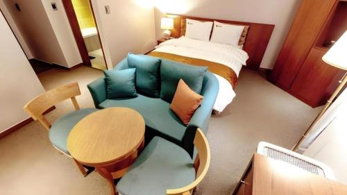 a room with a bed and a couch and a table at Hotel One Byeonsan in Buan