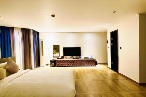 a hotel room with a bed and a flat screen tv at Hotel One Byeonsan in Buan