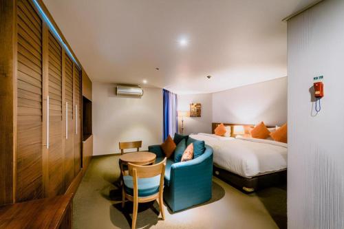 a hotel room with a bed and a table and chairs at Hotel One Byeonsan in Buan