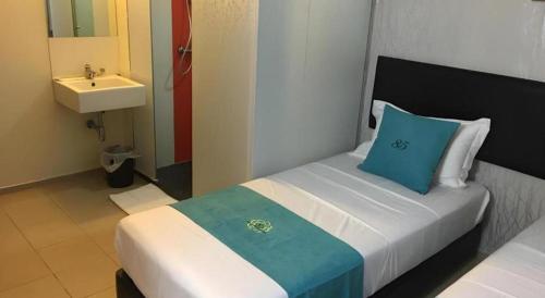 a bedroom with a bed with a blue pillow and a sink at 85 Beach Garden Hotel in Singapore