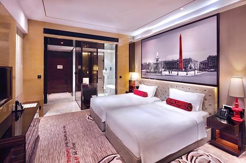 a hotel room with two beds and a television at Sofitel Guangzhou Sunrich - Free Shuttle Bus to Canton Fair Complex & Overseas Buyer Registration Services during Canton Fair Period in Guangzhou