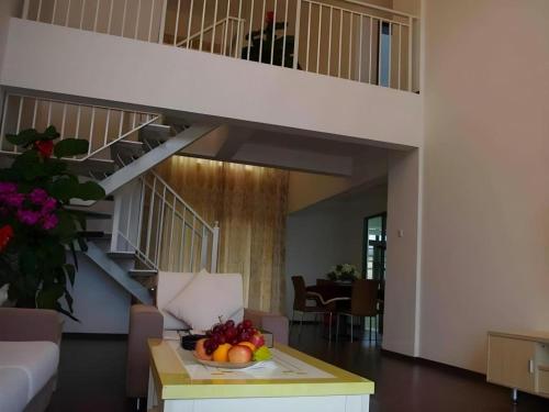 a living room with a bowl of fruit on a table at The Century Seaview Hotel in Shenzhen